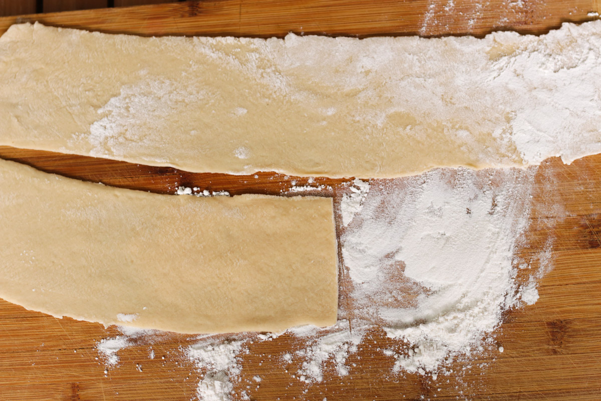 close up image of rolling out pasta sheets.