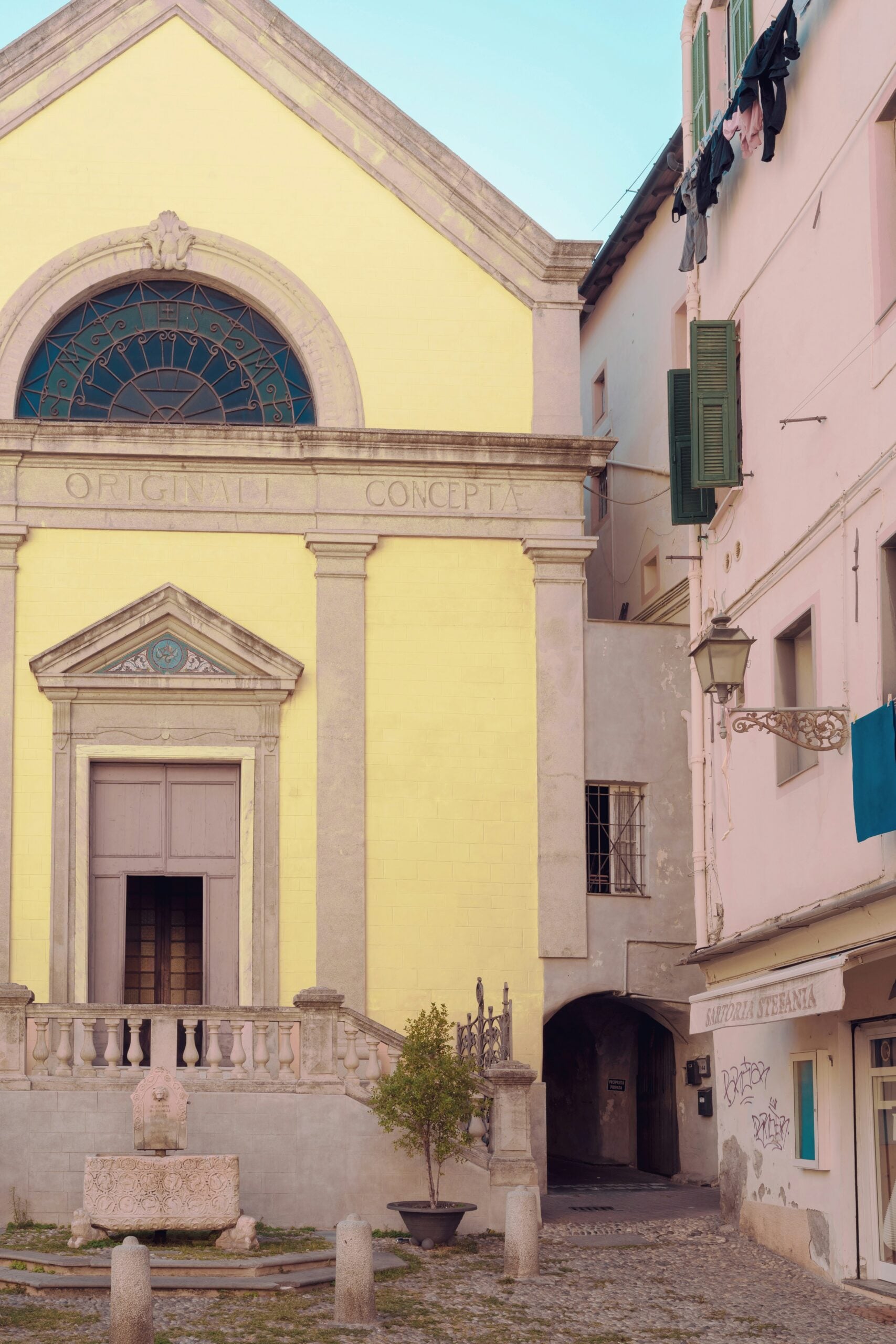 A charming image of an old yellow church in Sanremo, Italy, showcasing its weathered façade that reflects the town's rich history and Mediterranean charm. The church's simple yet elegant architecture includes arched windows, a modest bell tower, and a classic Italian terracotta-tiled roof. The warm yellow hue of the building, softened by years of exposure to the sun, adds to its timeless appeal. Surrounded by cobblestone streets and lush greenery, this quaint church is a peaceful and picturesque landmark in Sanremo, Italy, embodying the tranquil beauty of the region.
