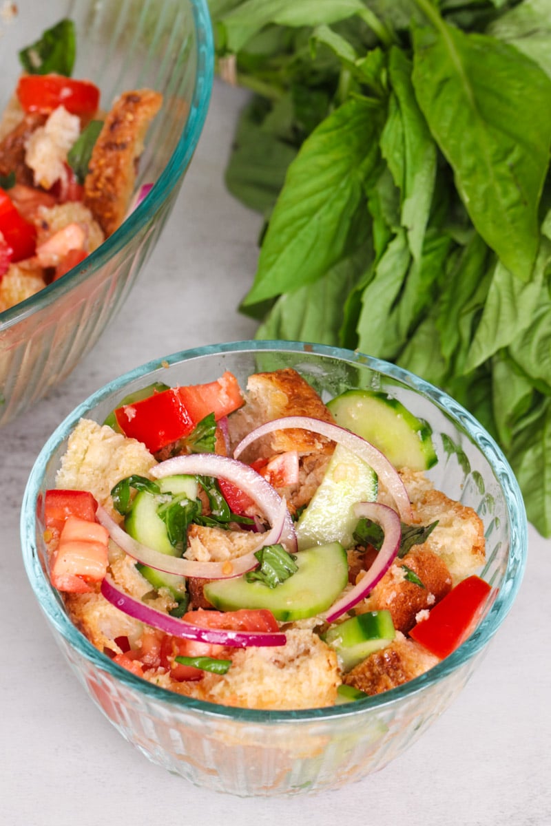 overhead image of panzanella salad in a glass bowl.