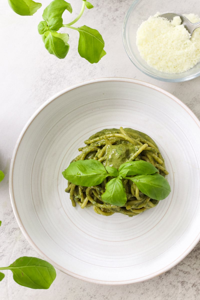 overhead image of pasta al pesto in a white bowl.