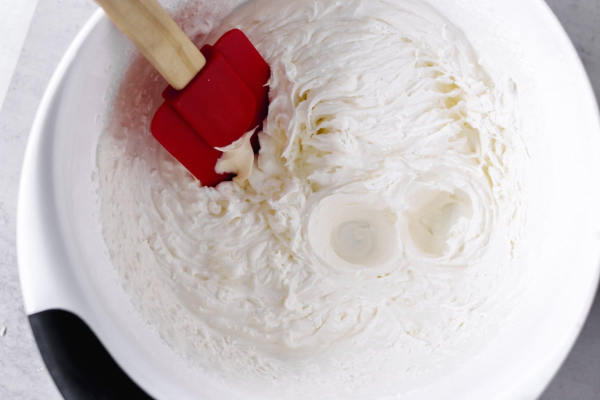 overhead image of whipping cream in a white bowl.