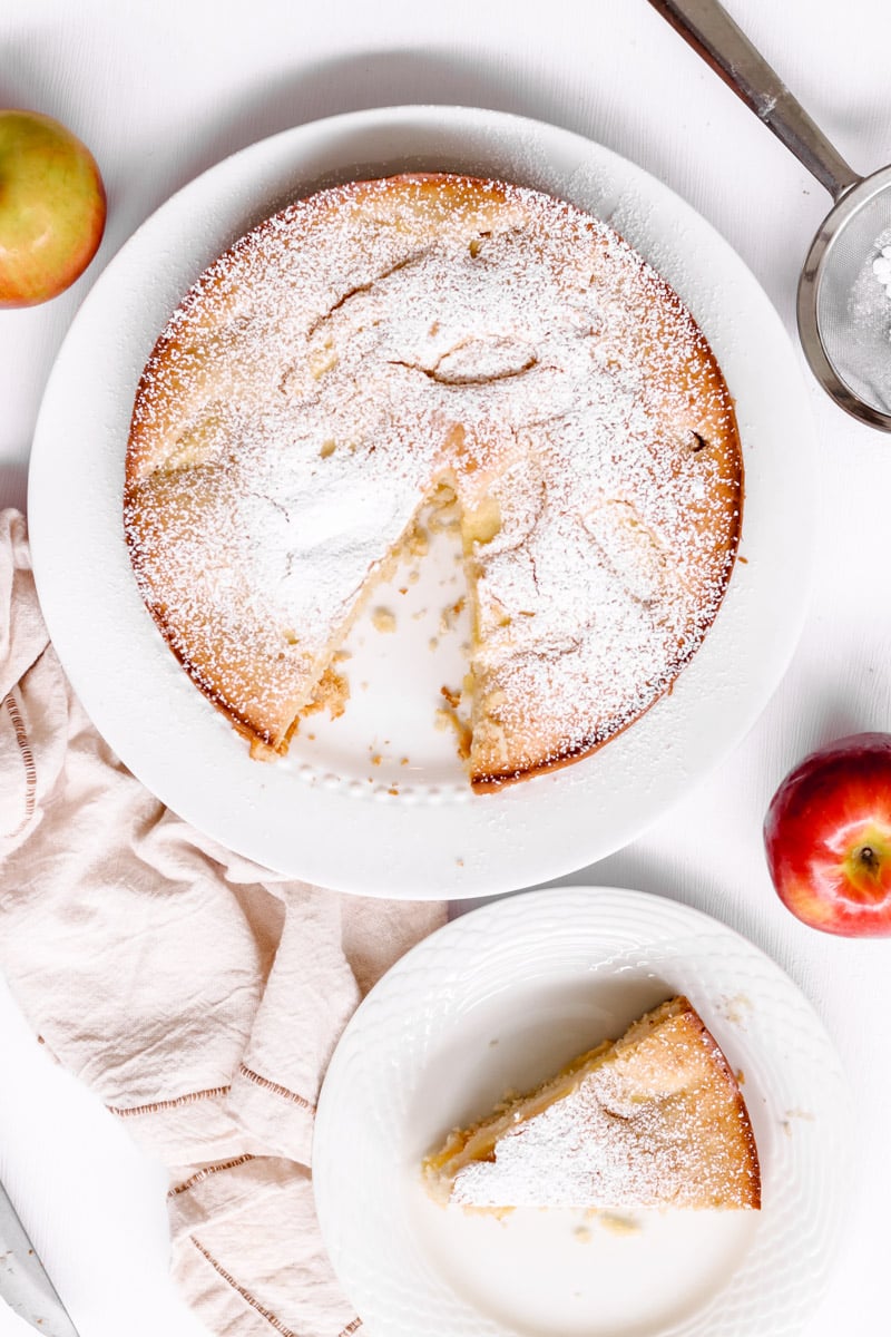 overhead image of an apple cake on a white plate.