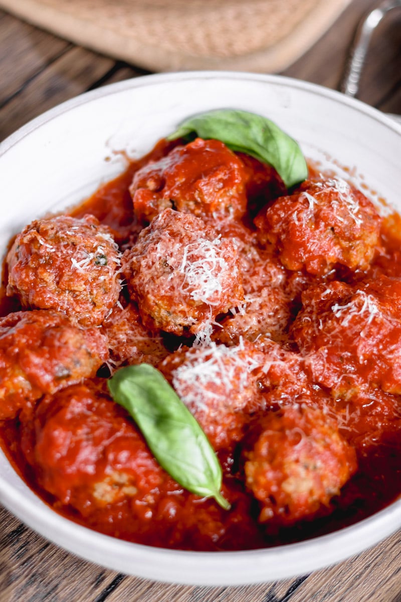 close up image of meatballs in a white bowl.