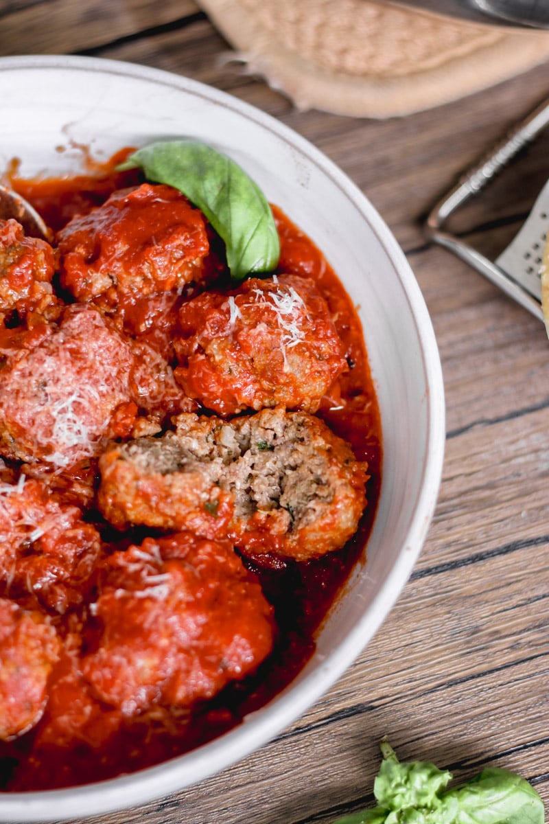 close up image of meatballs in a white bowl.