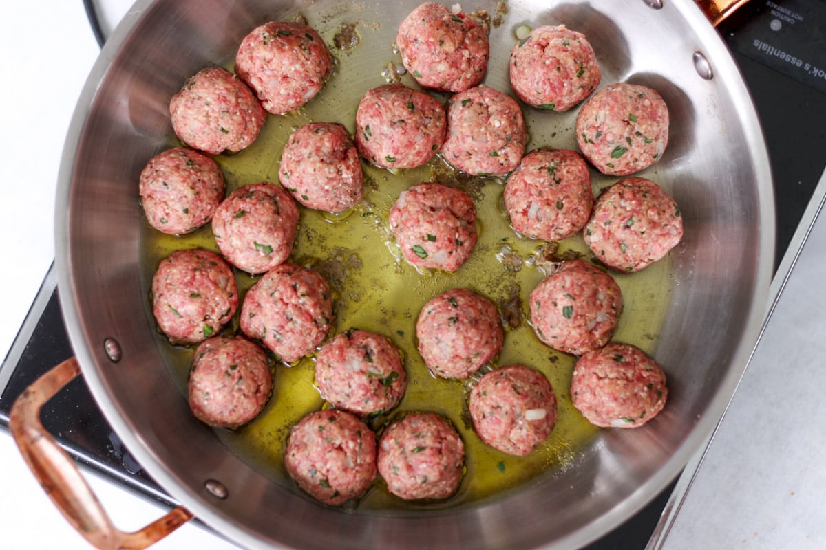 close up image of pan-frying meatballs in oil.
