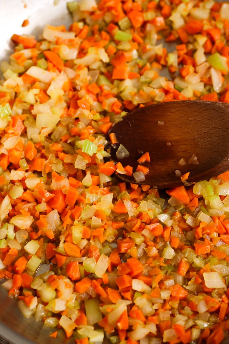 close up image of making soffritto and a wooden spoon.