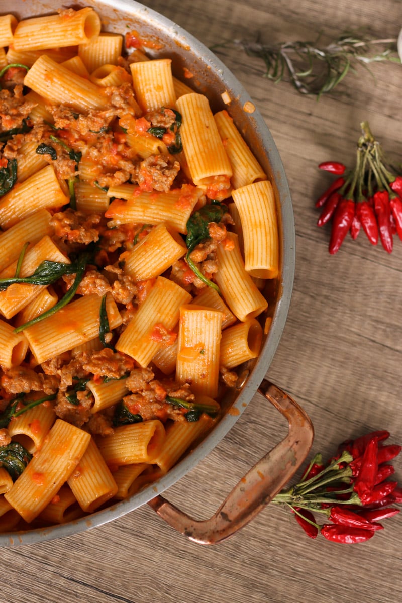 close up image of sausage rigatoni in. a skillet.