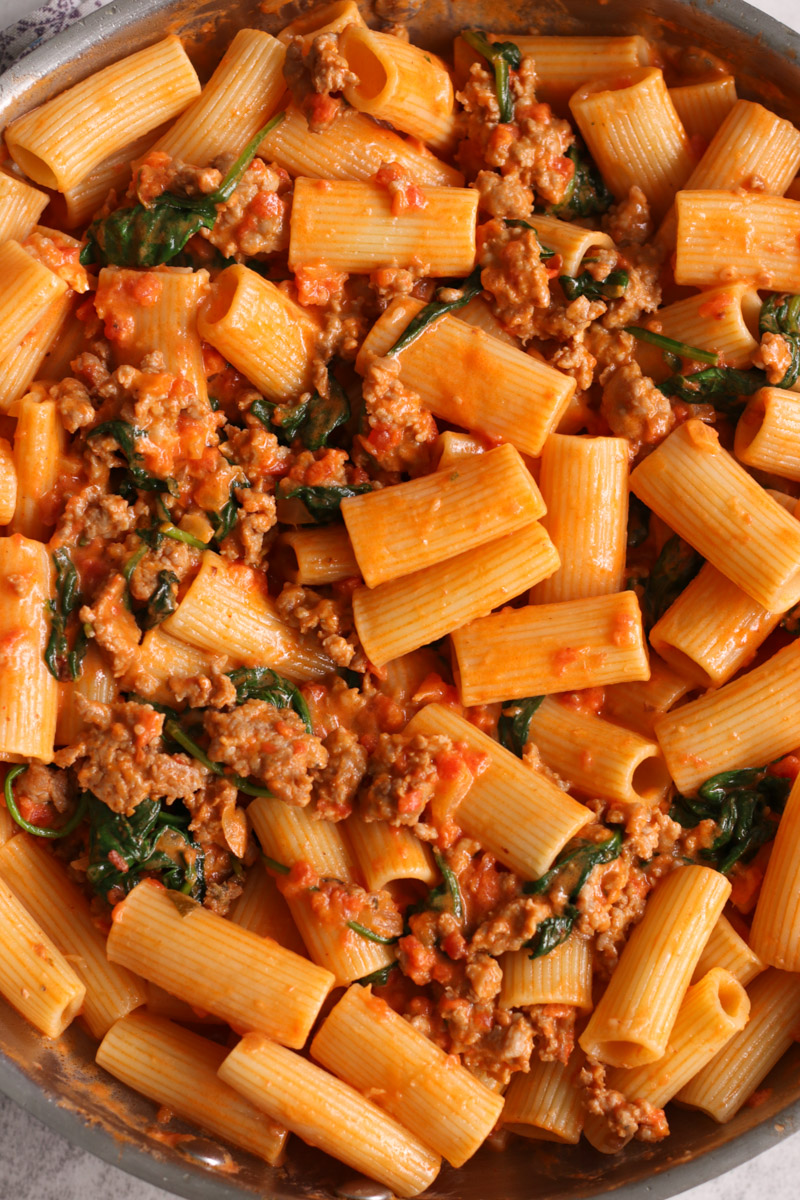 close up image of cooking sausage rigatoni in a skillet.