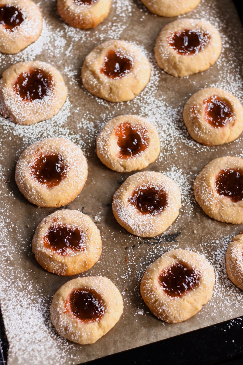 close up image of almond thumbprint cookies with jam.