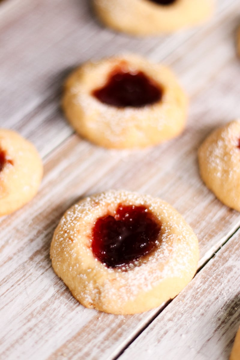 close up image of almond thumbprint cookies with jam.