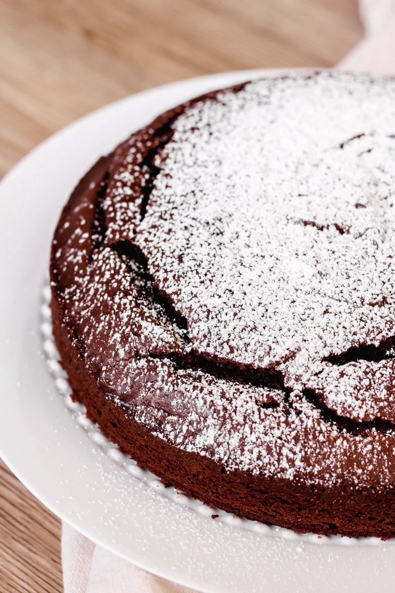 close up image of chocolate cake with powdered sugar on top.