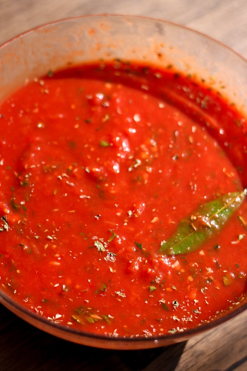 close up image of homemade pizza sauce in a glass bowl.