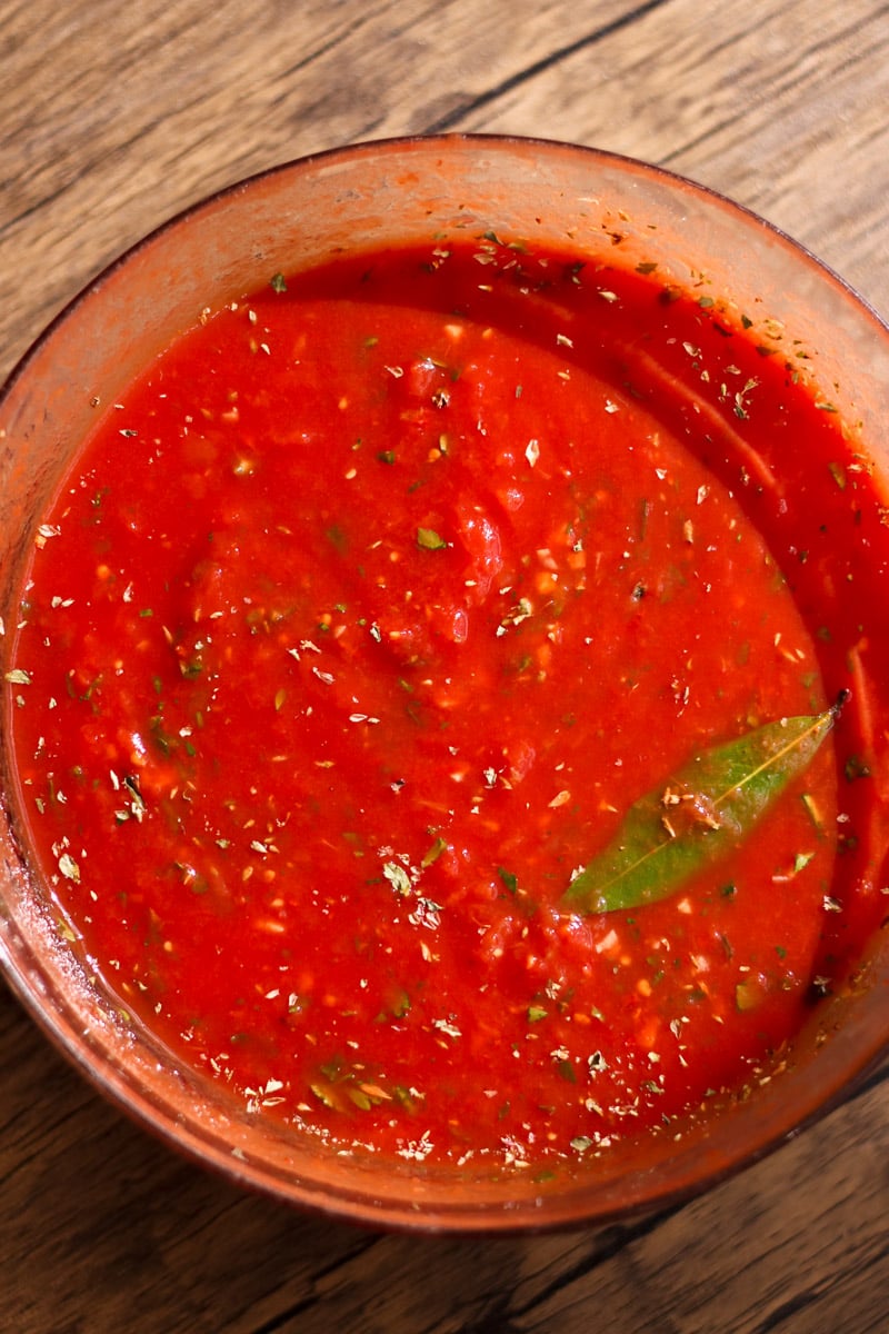 close up image of homemade pizza sauce in a glass bowl.