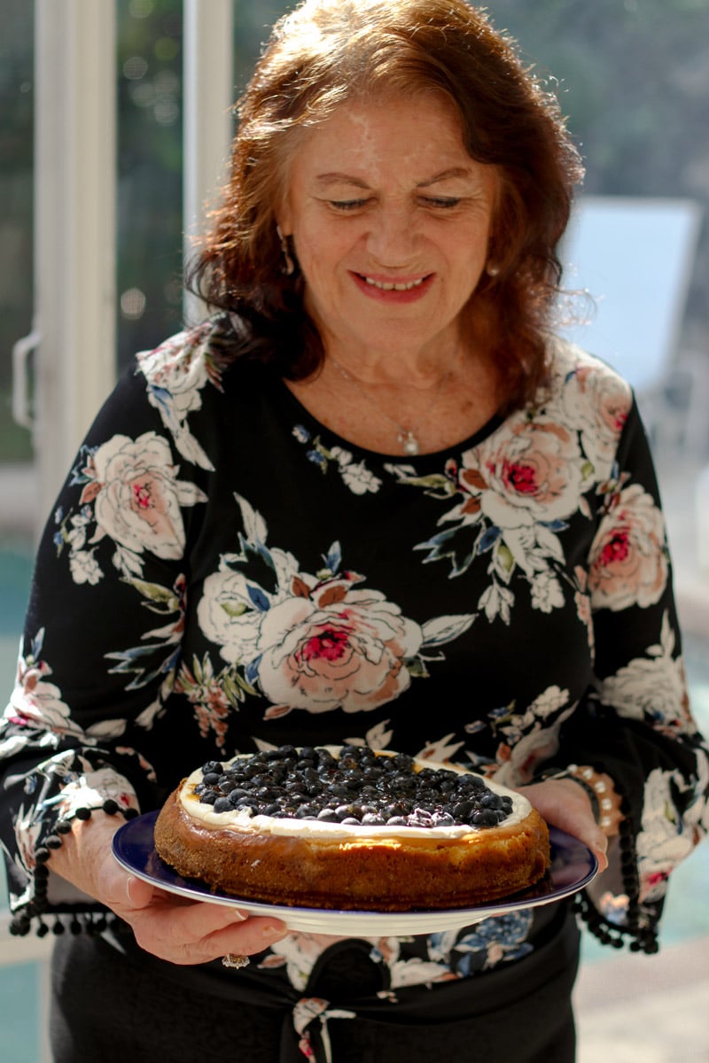 image of lady holding a cheesecake.