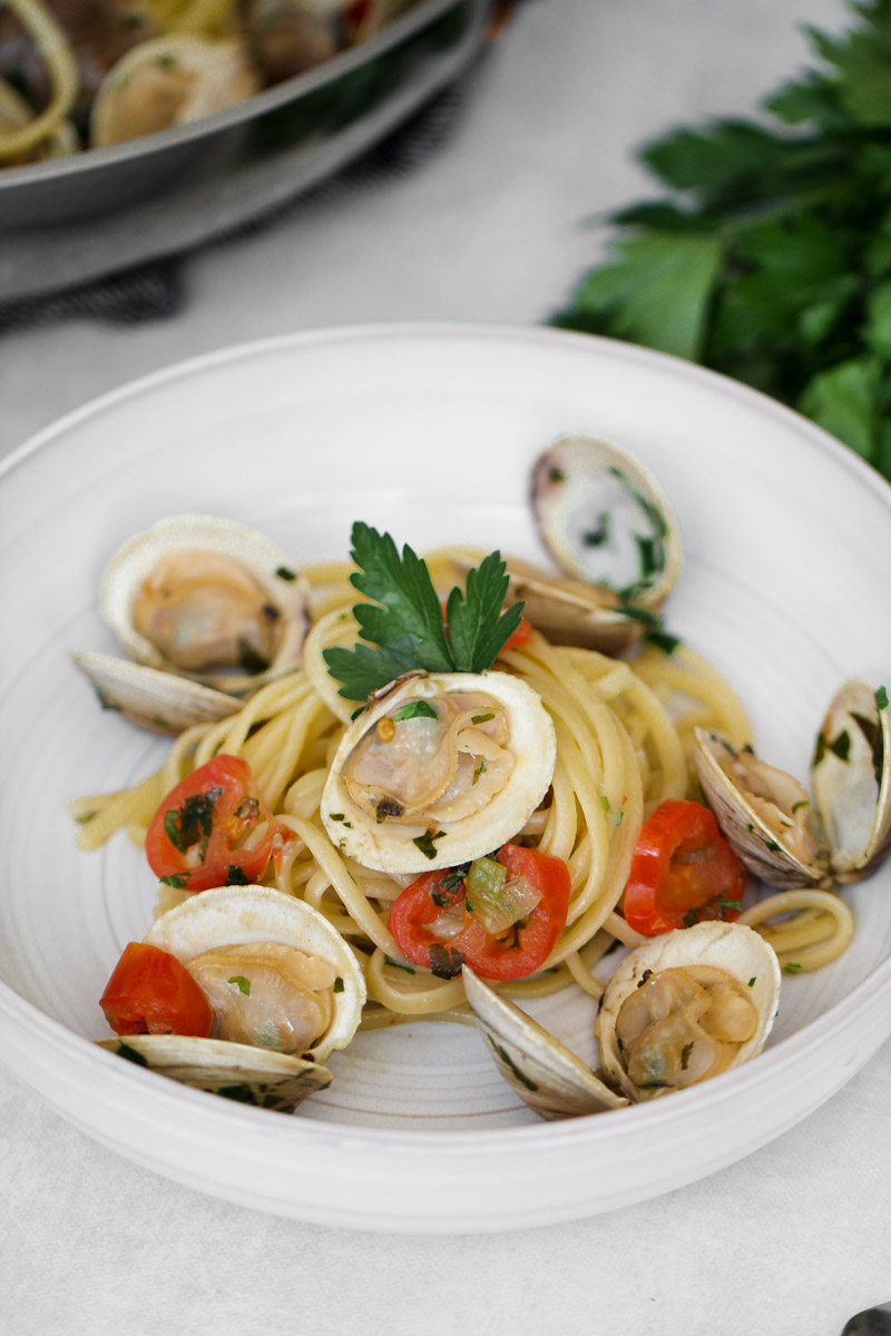 close up image of linguine con le vongole on a white plate.