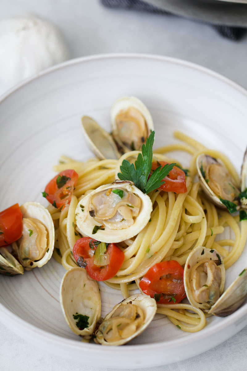 close up image of linguine con le vongole on a white plate. 
