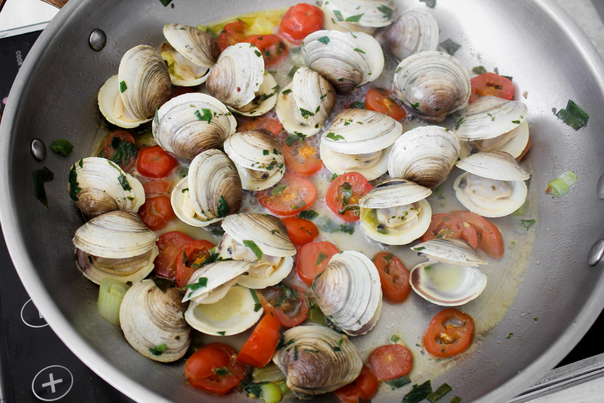 close up image of making clams in a skillet.