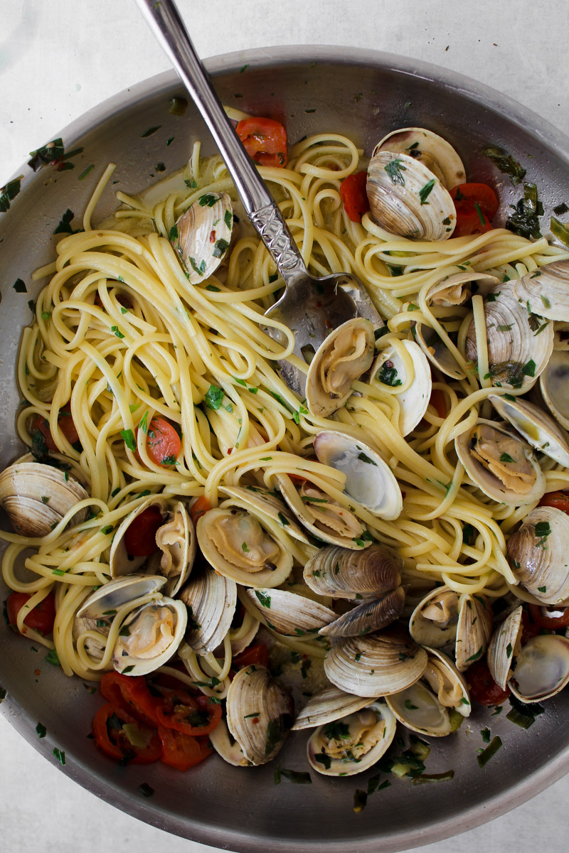 close up image of pasta with clams in a skillet.