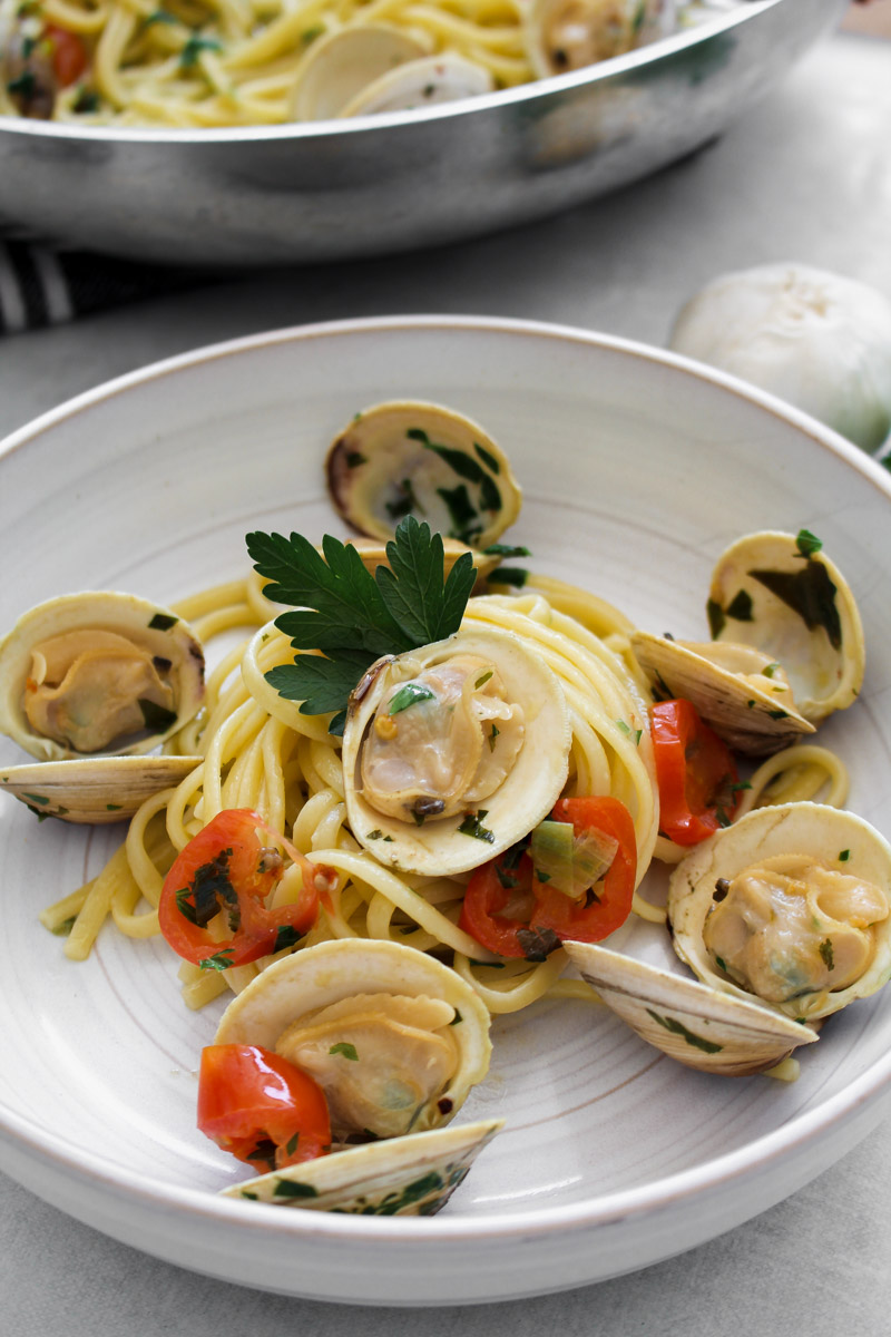 close up image of linguine con le vongole on a white plate. 