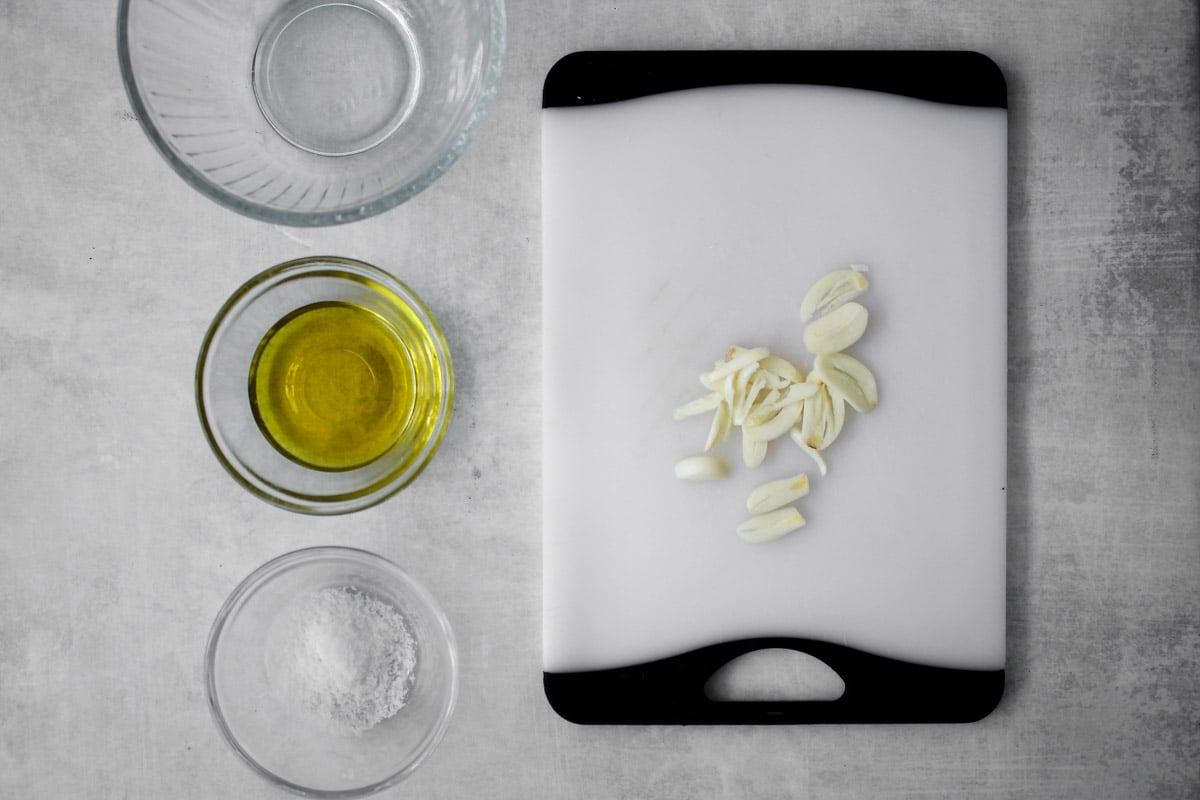 overhead image of sliced garlic on a cutting board.