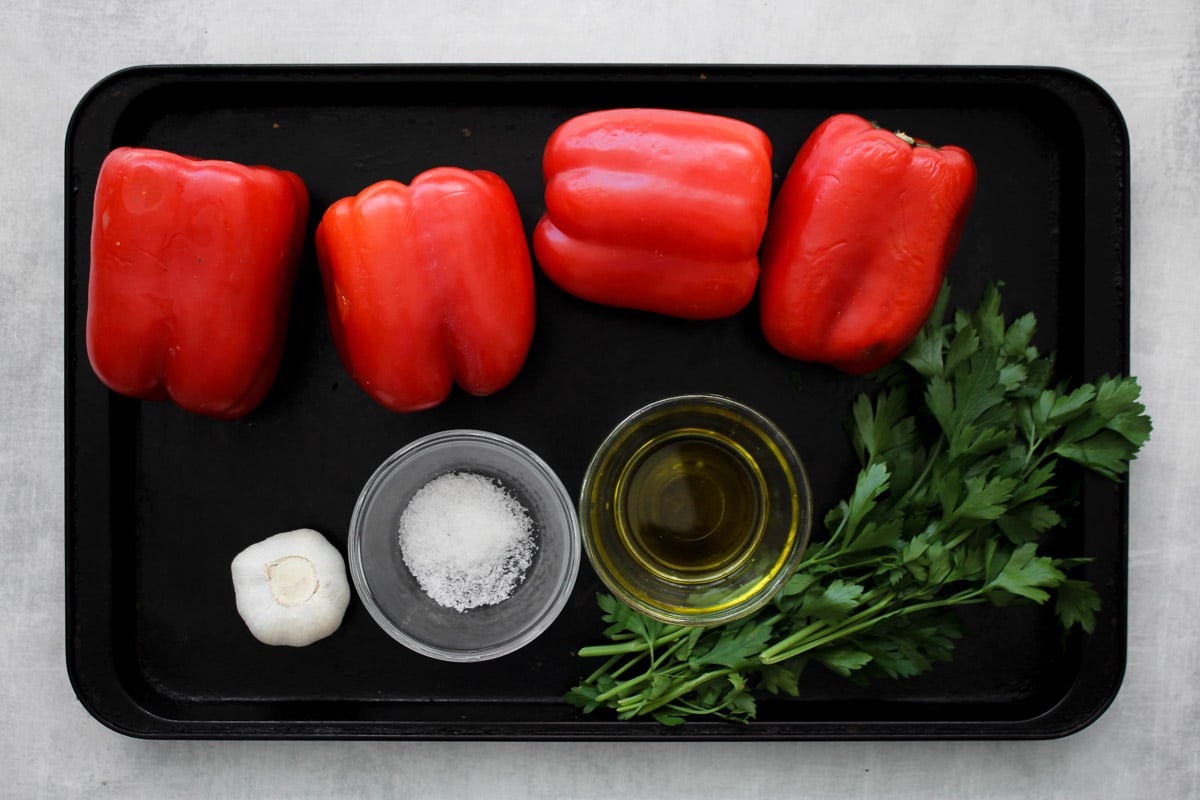 ingredients to make roasted red peppers on a baking sheet.