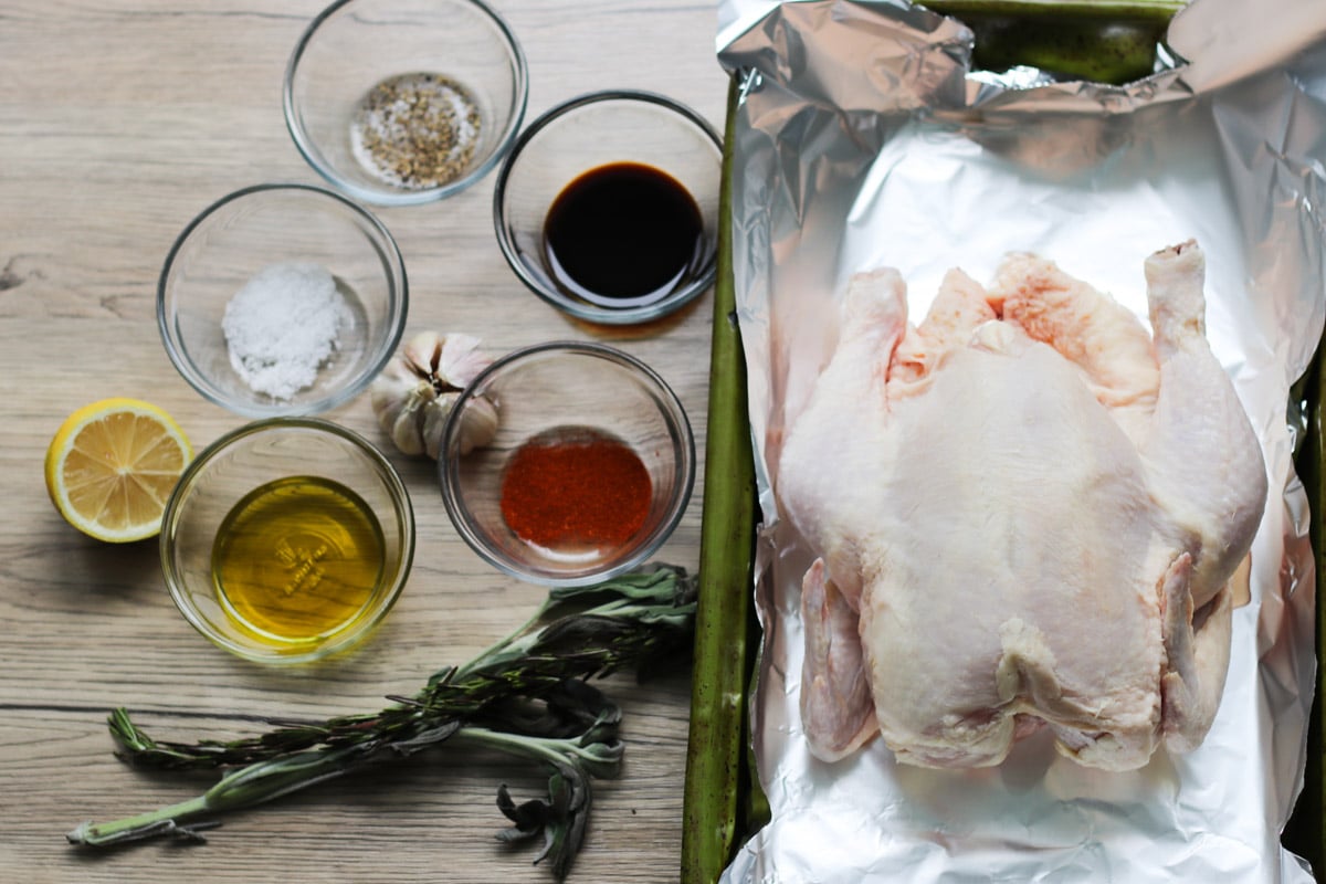 overhead image of ingredients to make a roasted chicken with lemon and herbs.