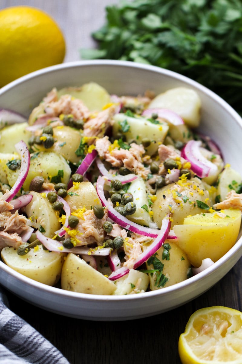 close up image of tuna potato salad in a white bowl.
