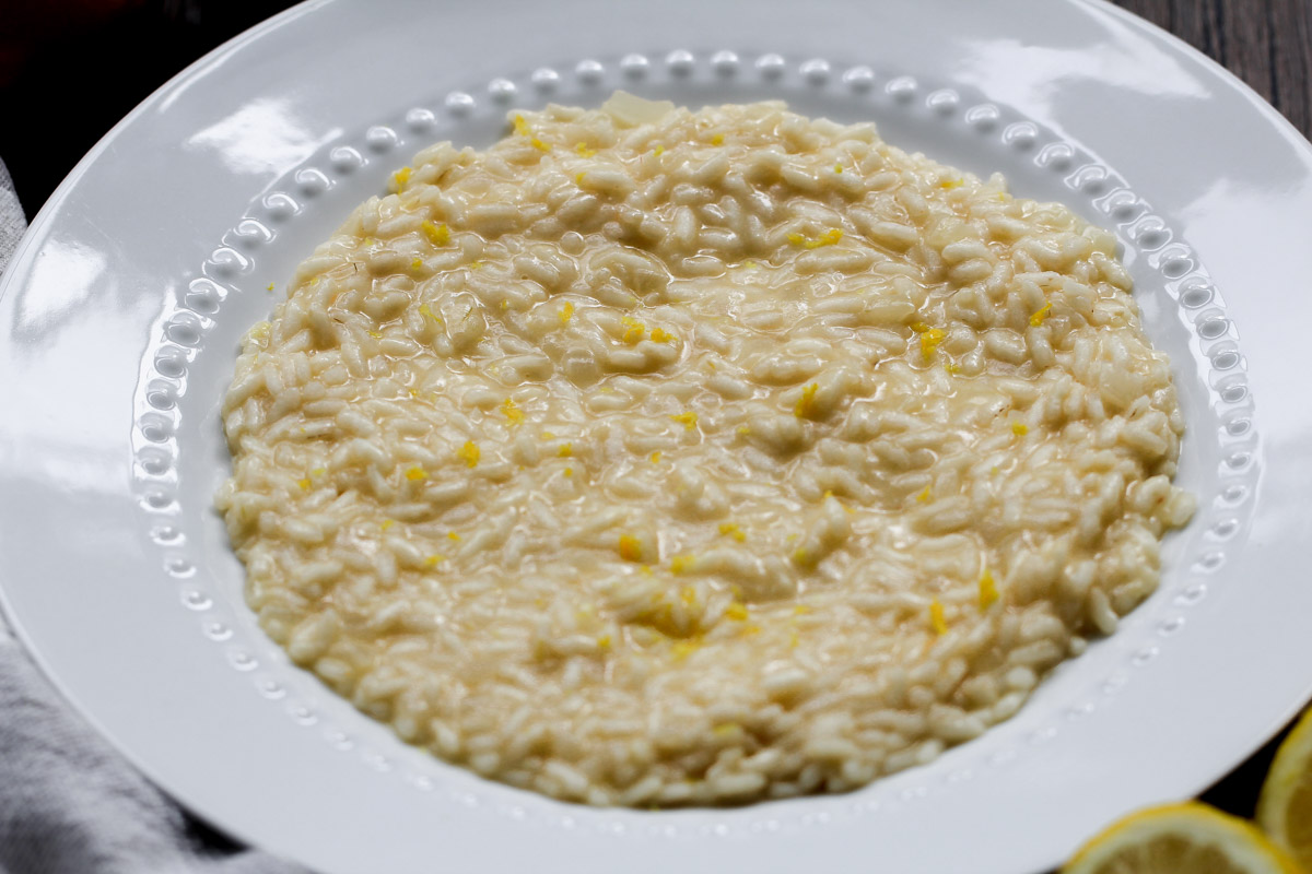 close up image of lemon risotto on a white plate.