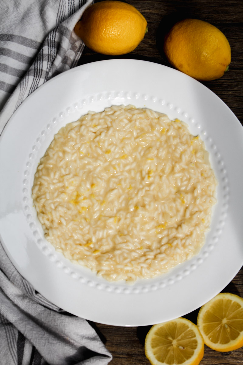 Overhead image of lemon risotto on a white plate.