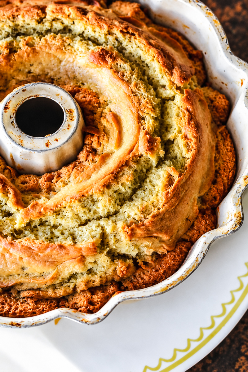 A freshly baked donut bundt cake in a fluted metal pan.