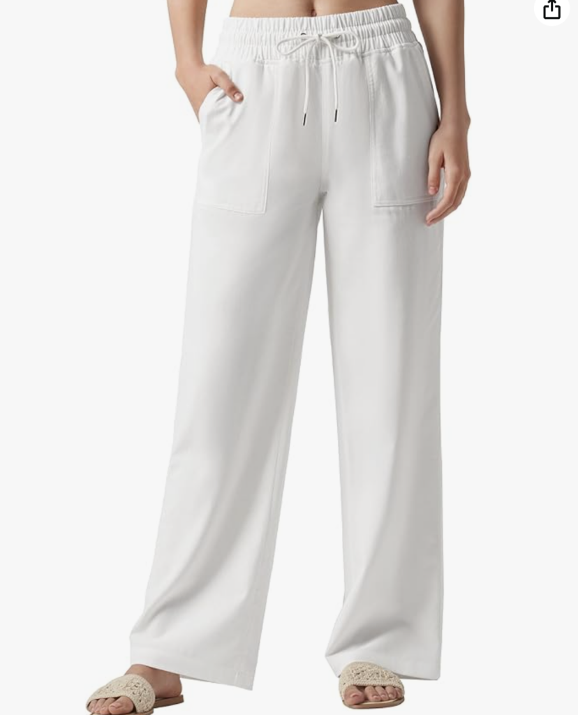 A person wearing loose-fitting white drawstring pants with large front pockets and open-toe beige sandals-an effortlessly chic look and a perfect example of what to wear in Italy for relaxed, casual style.