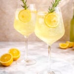 Two glasses of limoncello spritz. The scene is bright and refreshing.