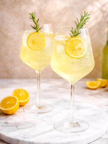 Two glasses of limoncello spritz. The scene is bright and refreshing.