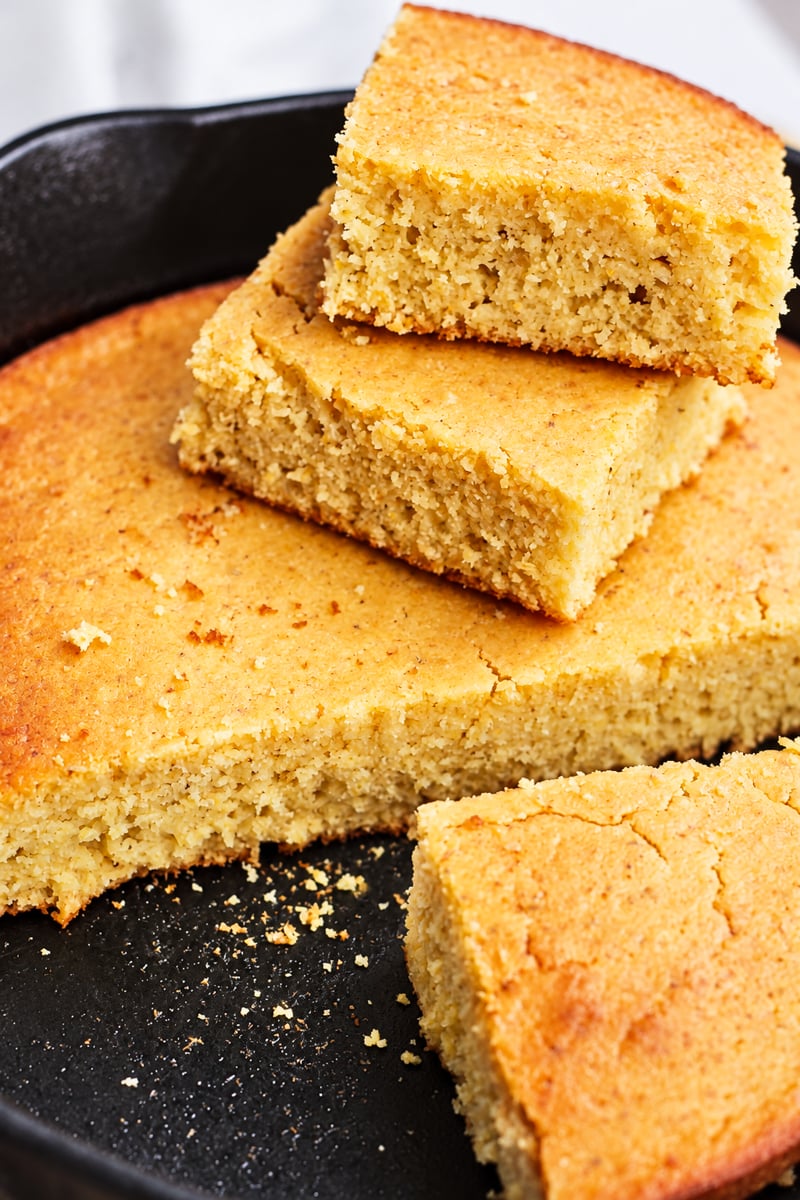 Grandmother's buttermilk cornbread sliced into pieces in a cast-iron skillet.